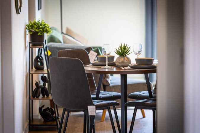 Airbnb dining area viewed from doorway with stylish table setup.
