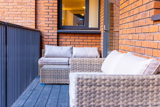 Airbnb balcony with stylish patio furniture and outdoor seating.