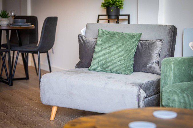 Airbnb living room with accent chair and dining area in background.