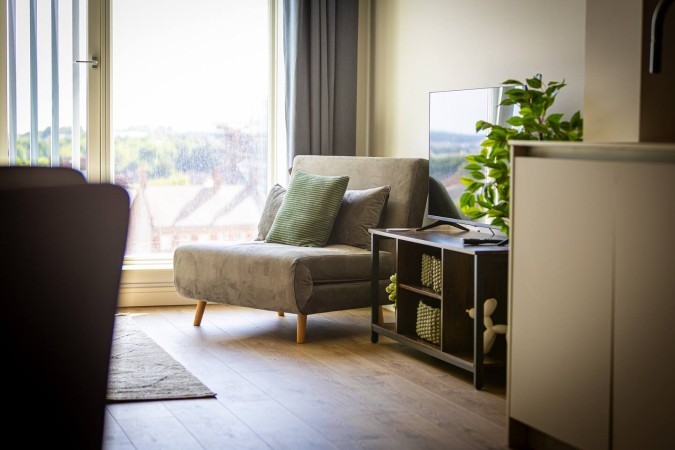 Bright Airbnb living room with accent chair and stylish flooring.