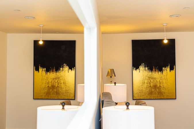 Modern Airbnb interior with contemporary canvas artwork and mirror.